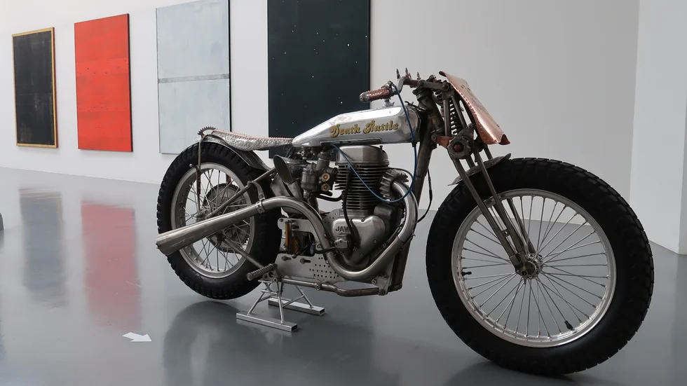 ”Death Rattle”, en av Engströms handbyggda motorcyklar. I bakgrund Karin Ögrens stora målarsvit.