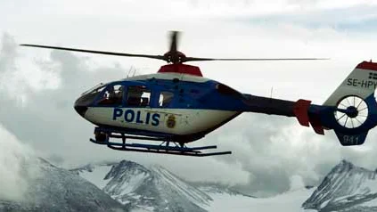 Polishelikopter går ner för landning i Ritsem, Ahkkamassivet i bakgrunden.