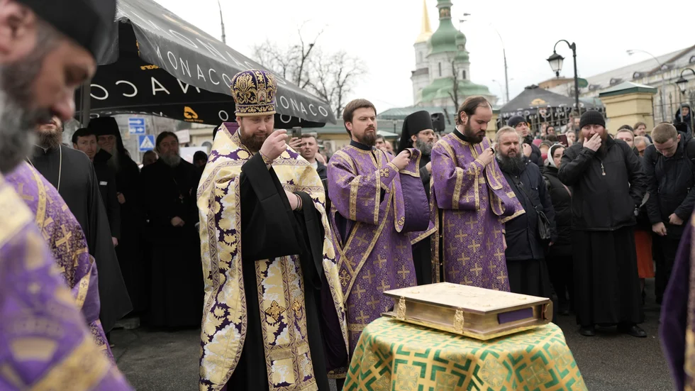 Präster inom den ukrainska ortodoxa kyrkan ber och visar sitt stöd till metropolit Pavel utanför klostret Petjerska i Kiev.
