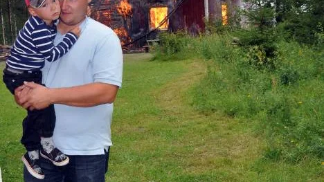 Barnbarnet Anders Boström var tagen. Hans morföräldrars stuga bär på många minnen som elden nu slukar. Lille Olle Boström minns att han i vinter åkt pulka vid gammelmormors stuga.                                                                                                  FOTO: Susanne Jansson