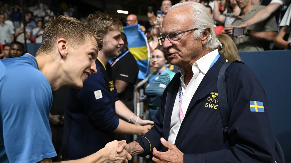 Sveriges Anton Källberg hälsar på kung Carl XVI Gustaf efter segern mot Tyskland i OS-kvartsfinalen i bordtennisens lagtävling.