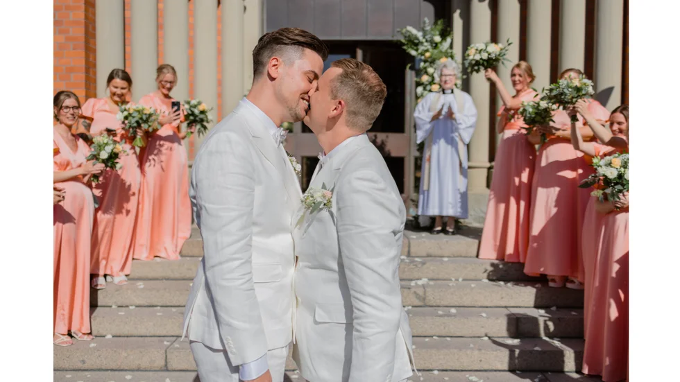 Jakob Andersson och David Holgersson gifte sig i lördags i S:t Petri kyrka. För tidigare kyrkoherden Britt Alf, i bakgrunden, var det första gången hon vigde ett samkönat par.