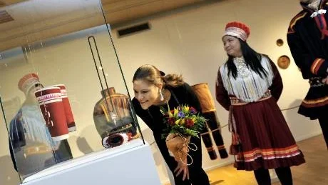 INTRESSERAD. Kronprinsessan Victoria studerade utställningen, som eleverna vid Samernas utbildninscentrum har, noggrant. Mikaela Unga Pirak överlämnade en väska som hon gjort vilken skolan köpt till present. Rektor Per Michael Kuhmunen till höger.