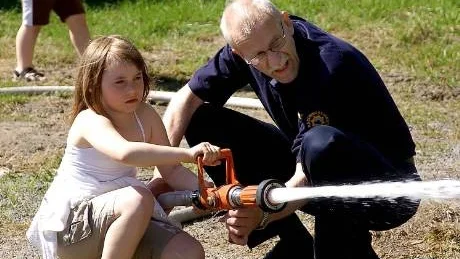 PRECISION. Lilly Nordberg får hjälp av Michael Sundberg att hantera brandsprutan på Öppet hus hos Räddningstjänsten.