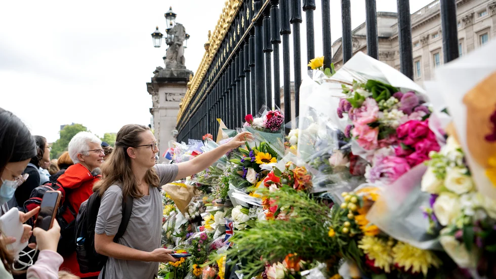Människor lägger blommor utanför Buckingham Palace i London.