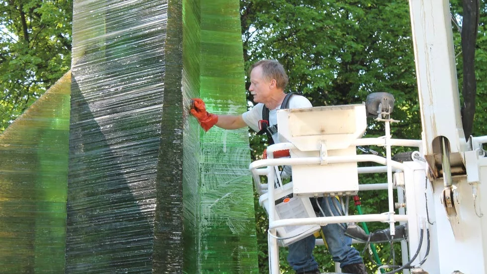 Renovering. Leo Lindstrand lägger en vårdande hand vid sin farfars skulptur Prisma, den  11,5 meter höga glasobelisken vid Olof Palmes plats i Norrköping.
Foto: Sara Segraeus