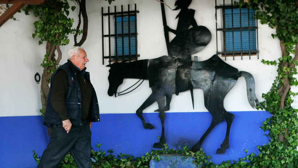 En man går förbi en bild av "Don Quijote" i La Mancha, Spanien. Arkivbild.