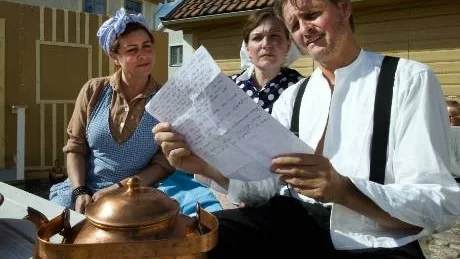 Systrarna Anna (Cecilia Lundholm-Pålsson) och Kristina (Lotta Appelvang) tittar intresserade på brevet från andra       sidan Atlanten som Annas make Johan (Stephan Grönroos) läser ur.