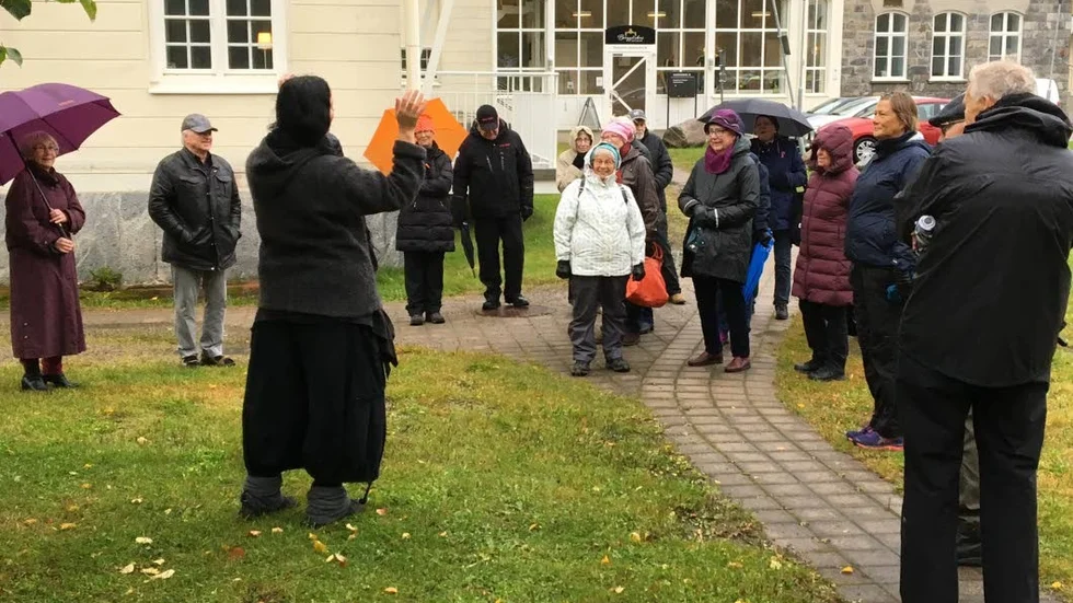 Några deltagare framför Furunäsets fd sjukhus värms av framförandet.