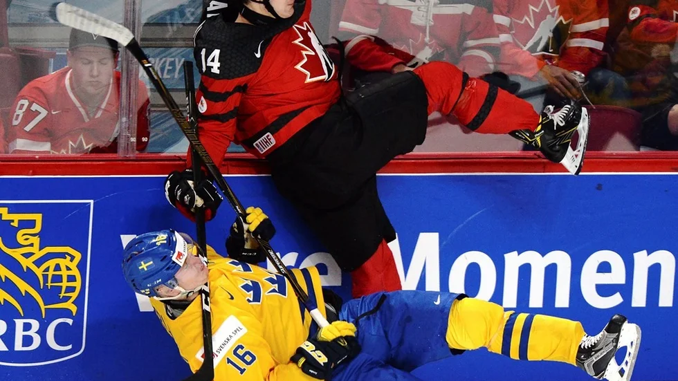 Canada's Matt Barzal (14) and Sweden's Carl Grundstrom (16) battle along the boards during the first period of a semifinal game at the World Junior ice hockey championships, Wednesday, Jan. 4, 2017 in Montreal. (Paul Chiasson/The Canadian Press via AP)