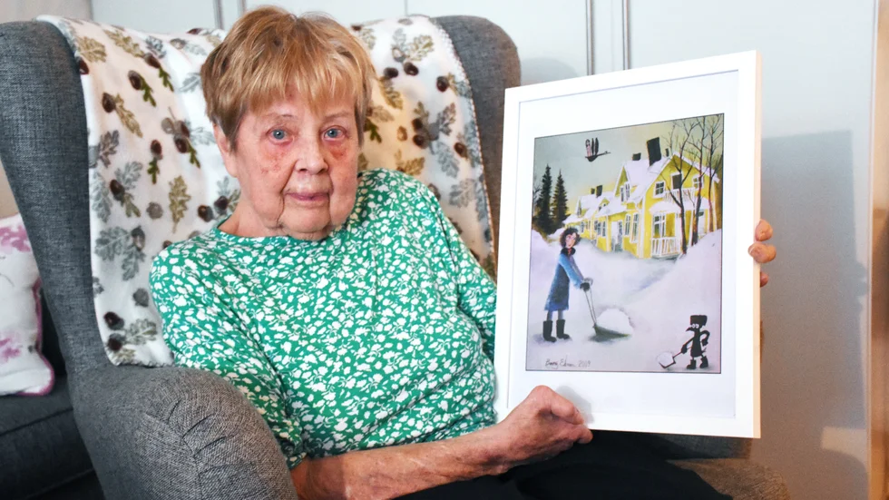 Eida Jatko bodde i Gula raden i 19 år. Nu har huset flyttat till ny adress på grund av stadsflytten. På bilden syns Benny Ekmans målning av Gula raden.  