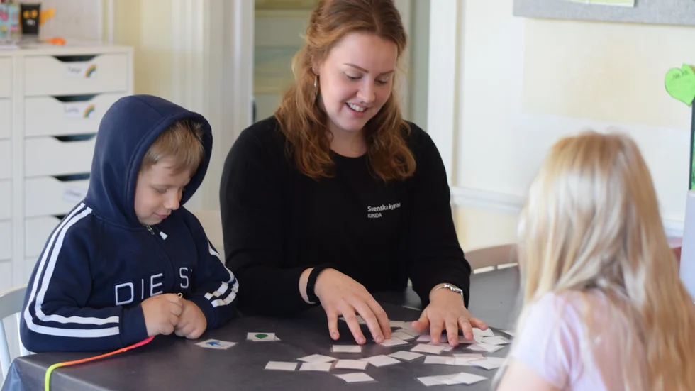 Pedagogen Sara Nilsson och barnen Oliwer Gaines och Thea Hjelte spelar memory. Alla tre tycker att det är vitkigt att jobba för en hållbar utveckling.