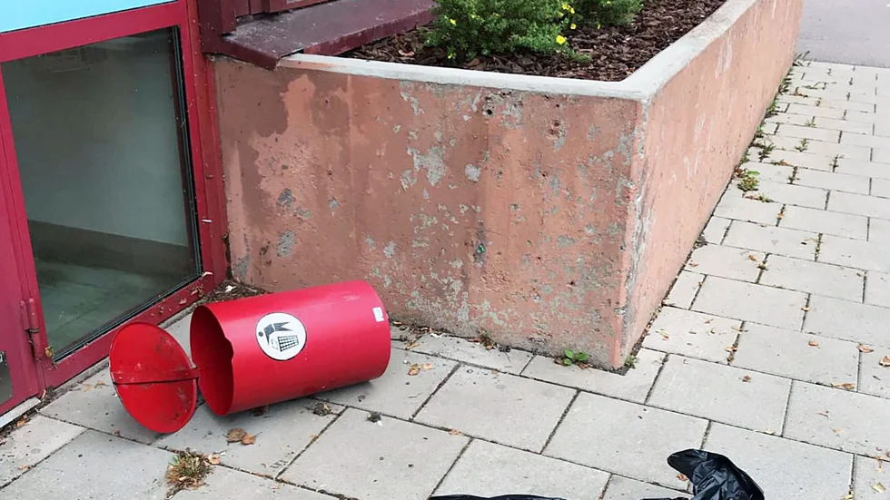 Soptunnan slets loss från betongmuren vid polishusets entré.