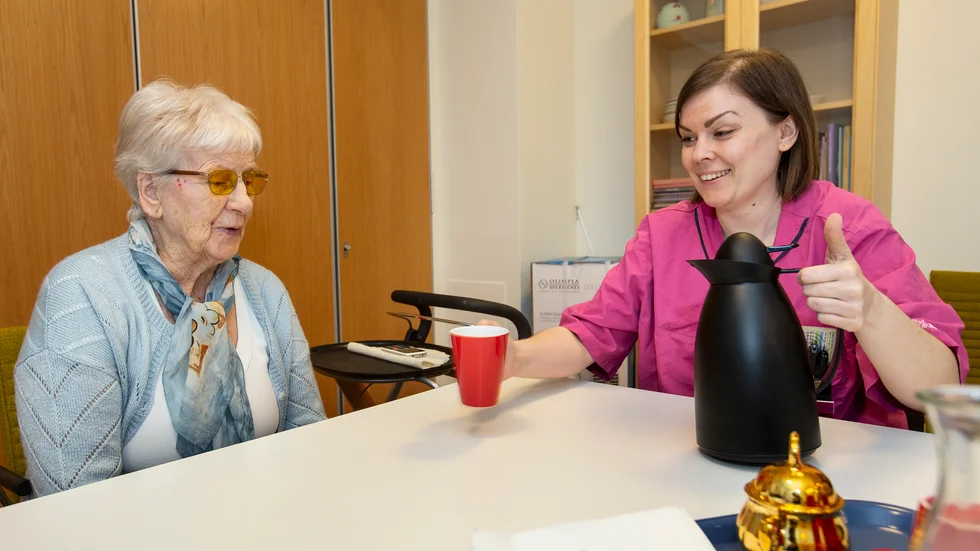 Sonja Andersson känner oro för smittspridning av coronaviruset. Hon får en kopp kaffe av Stina Avelin, sjuksköterska på Hasselparkens äldreboende.