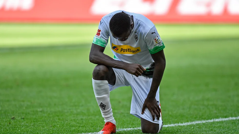 Borussia Mönchengladbach Marcus Thuram ställer sig på ett knä sedan han gjort mål mot Union Berlin.
