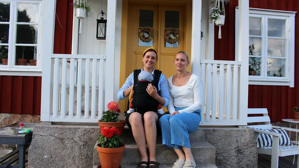 Systrarna Rebecca Seavers och Deborah Seavers Jansson är grannar, i alla fall när de befinner sig i småländska Torpa där de köpt var sitt torp. Här på trappan hos Rebecca som har Vibjörn i famnen.