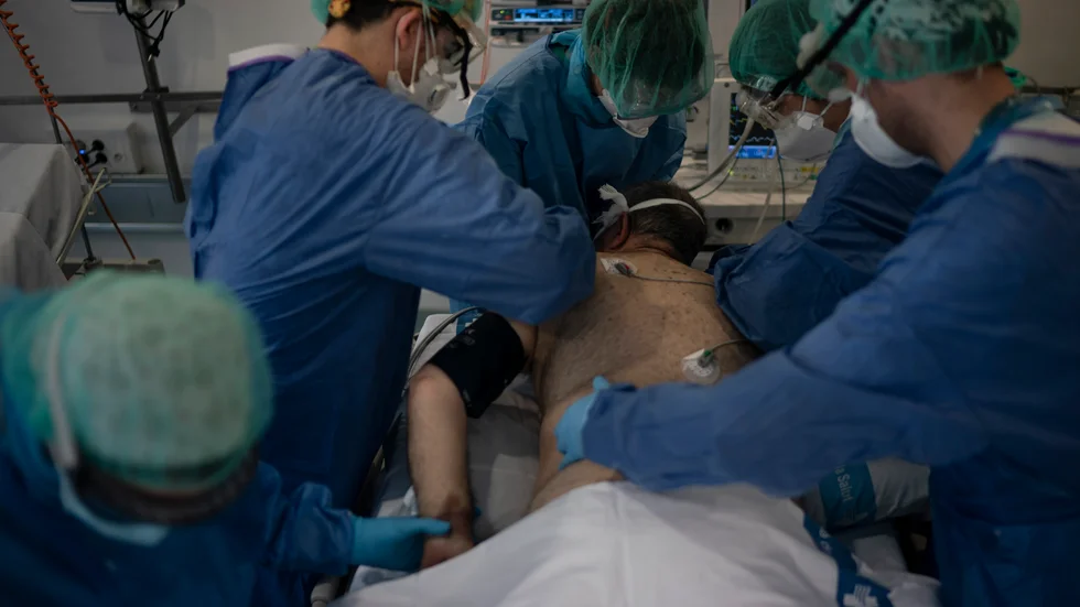 Vårdpersonal tar hand om en covid-19-patient på ett bibliotek som gjorts om till tillfälligt sjukhus i Barcelona, Spanien.