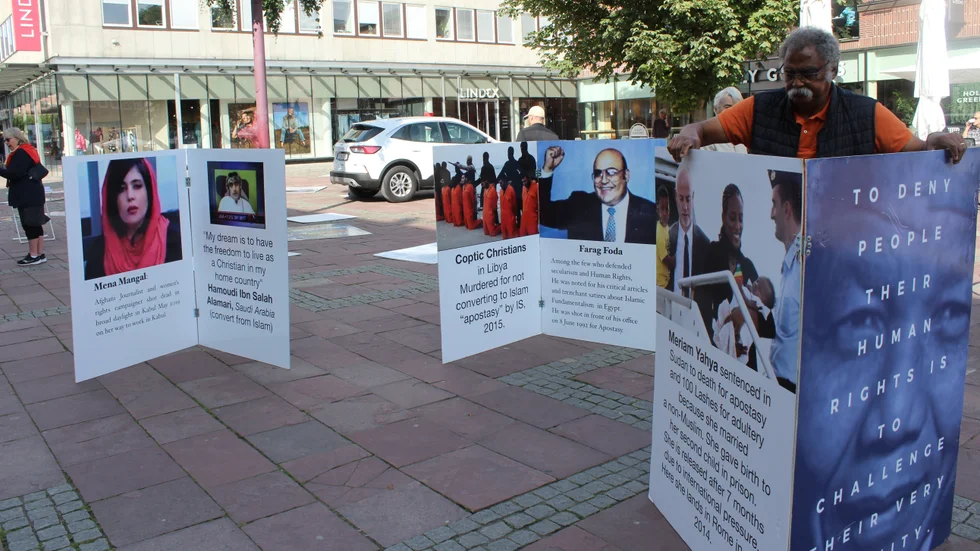 Nätverket Set Me People Free satte på tisdagen upp en skärmutställning på Lilla torget för att uppmärksamma offer för religiöst betingat våld. Kamal Fahmi hade det tufft. Starka vindpustar gjorde att skärmarna ideligen blåste ned.