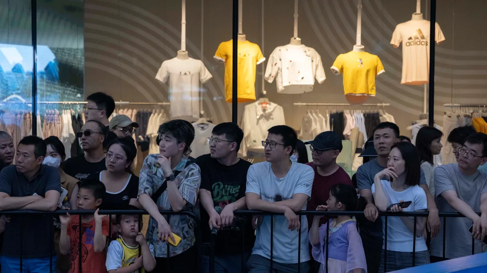 Människor utanför ett shoppingcenter i Peking. Arkivbild.