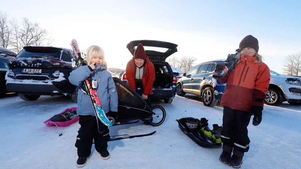 Systrarna Hedvig och Sigrid Bjonholm laddar för utförsåkning. Mamma Emelie stoppar om tre veckor gamla lillebror Svante i vagnen.