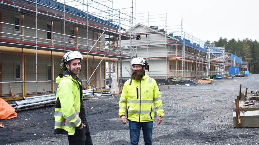 Arbetsledare William Nyström och platschef Mattias Edlund bland de hus som fortfarande är under produktion.