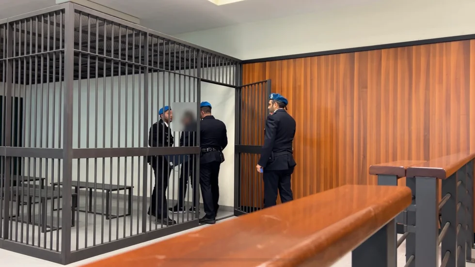 Den misstänkta 73-åringen låses in i en bur i rättssalen.