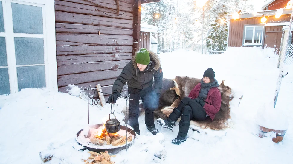 Tekokning över öppen eld och en stund på renskinnen vid den vackra timrade väggen. Det är en tillvaro som verkligen tilltalar det unga brittiska paret. 