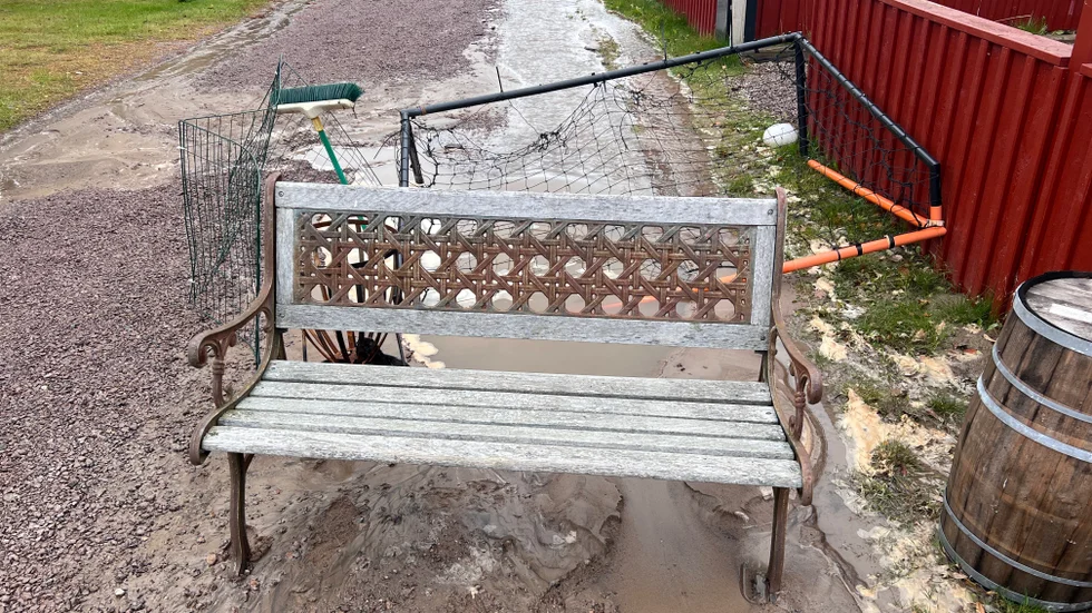 Soffor och andra grejer är utplacerade som skydd över vattenhålet som uppstått av vatttenläckan i vägen.