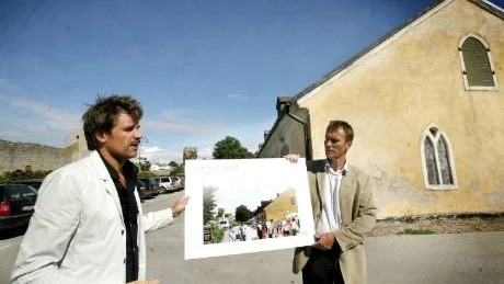 Saluhall. Arkitekten Andreas Forsberg och kommunalrådet Lars Thomsson (C) visar upp en skiss på hur lagerbyggnaden i bakgrunden kan se ut omvandlad till saluhall.