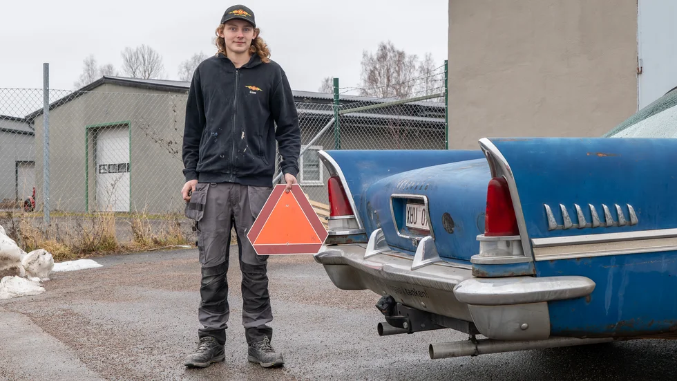 Liam Vanberg håller i LGF-skylten som inte behövs längre på hans Chrysler. Nu får bilen köra fortare än 30 km/h igen.