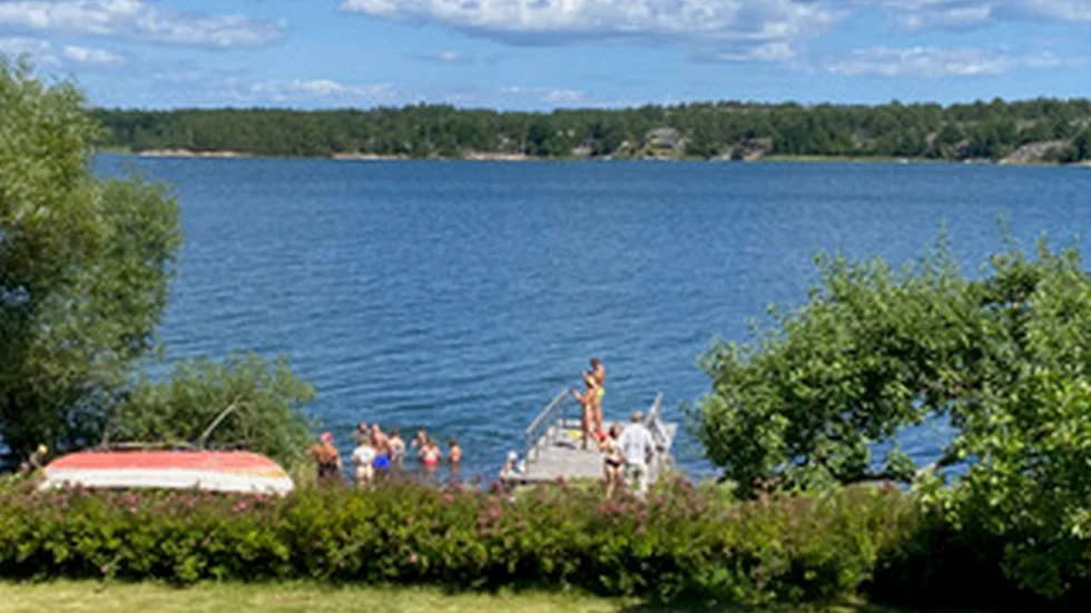 Så här kan den se ut en vacker sommardag vid en privat brygga längs Gamlebyviken, med utomstående som nyttjar bryggan för bad och rekreation. Ändå tvingas brygghållaren betala höga avgifter för både bryggplats och underhåll. Skribenterna vill nu att kommunen ser över villkoren för både små och stora bryggor.