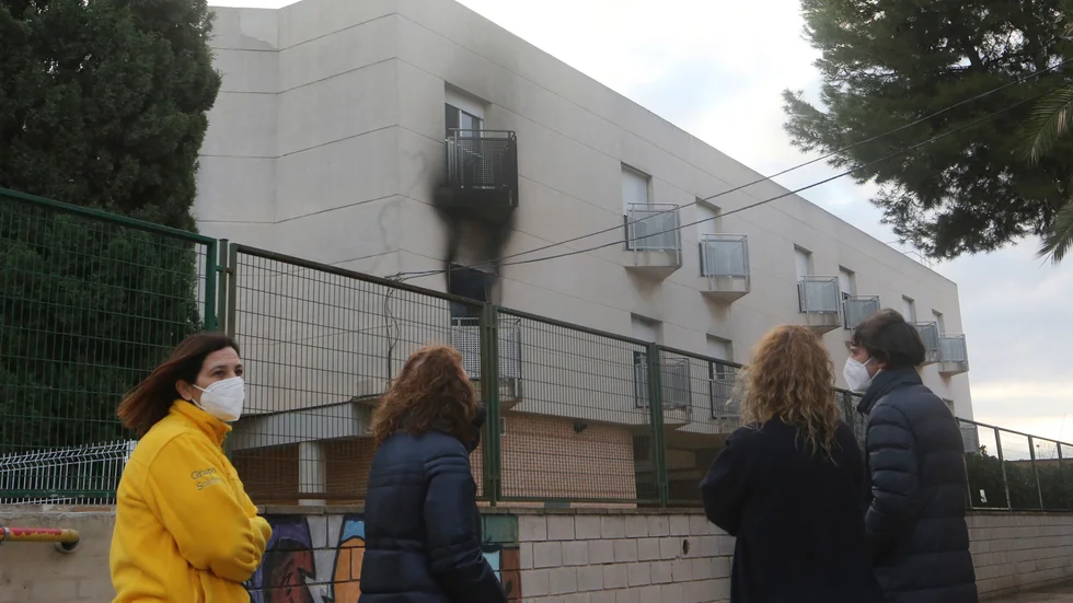 Nyfikna utanför den brandhärjade fastigheten i Moncada nära Valencia.