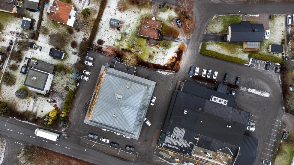 Här ser vi en drönarbild på Krokek centrum. Skribenten är kritisk till att Norrköpings kommun tänker sig att anvä'nda samma parkeringsnorm i Krokek som i Norrköping city. "Tommy" är också skeptisk till hur det ska skapas "trevliga utemiljöer" i området. 