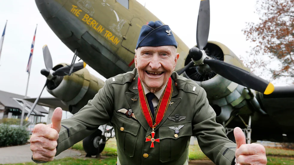 Gail "Candy bomber" Halvorsen ger tummen upp framför ett gammalt militärt transportflygplan med namnet The Berlin Train i Frankfurt i november 2016.