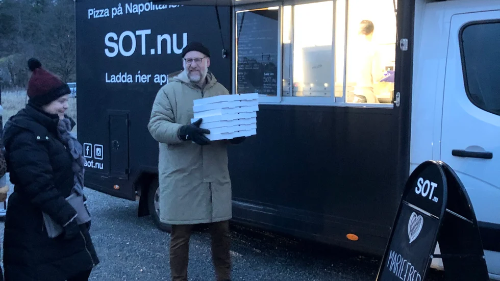 Två av de första kunderna på premiärdagen i Mariefred hämtar nygräddade pizzor.