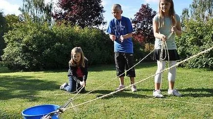 Victoria Wiberg Lindau och Johanna Swanelius försöker dra åt sig hinken med godis ivrigt påhejade av lagkompisen Axel Jansson.
