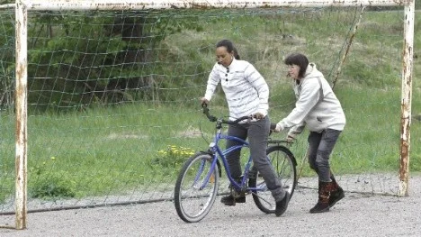 Mihvet Keleab Solomon lär sig cykla i Gimo.Hon får hjälp av Susanne Wahlstrand.