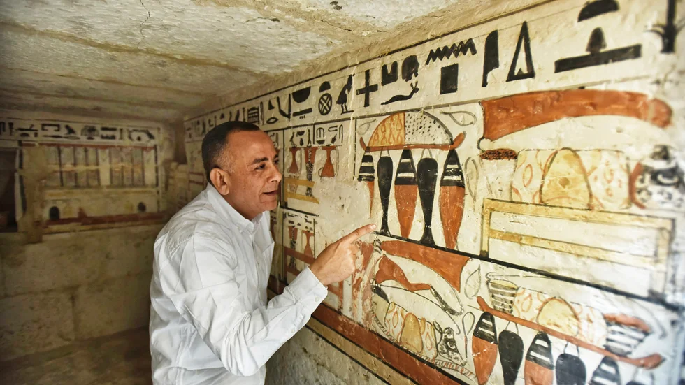 Mostafa Waziri, generalsekreterare för Egyptens antikvitetsmyndighet, tittar närmare på hieroglyferna i en nyligen hittad grav.