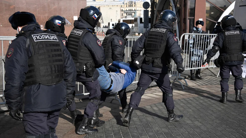 Poliser bär i väg en demonstrant på Manegetorget i centrala Moskva på söndagen.