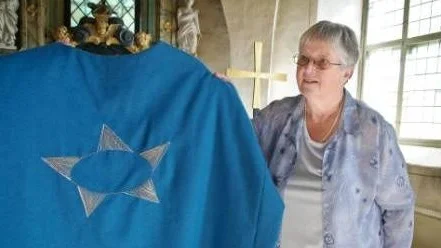 Föreningens ordförande Elisabeth Kjellén med en mässhake som föreningen skänkt till kyrkan.