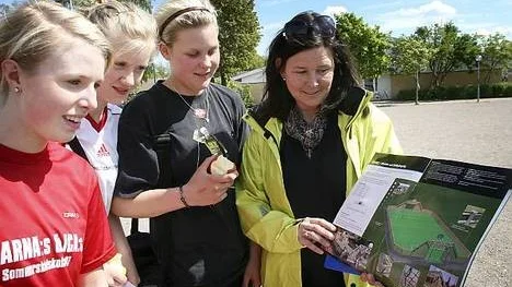 Sofia Torstensson, Julia Jansson och Lisa Björ studerar  idrottsläraren Mariette Bellqvists skiss på den nya konstgräsplanen.
