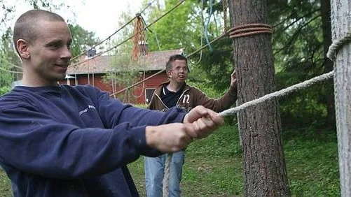 Mikael Lindgren visar sin bror Linus Eriksson hur man gör en knop.