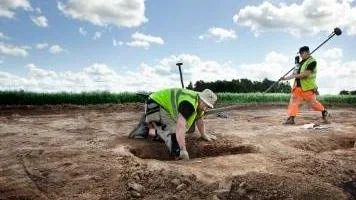 Fredrik Thölin, arkeolog SAU, och Robin Lucas, arkeolog Upplandsmuseet, gräver upp fynd.