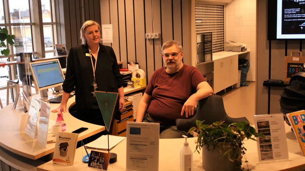 Tina Juhlin och Lars Jansson håller ställningarna i receptionen. De tror att biblioteket hjälper mot ensamhet.