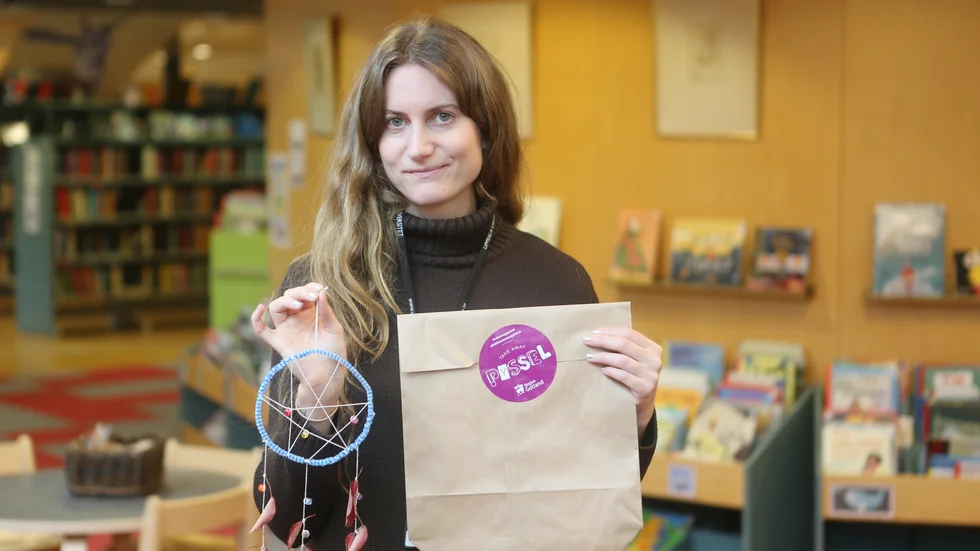 I bibliotekens pysselpåse finns instruktioner och grundmaterial till att bygga en egen drömfångare. Biblioteksassistent Felicia Sjögren visar hur en färdig fångare kan se ut.