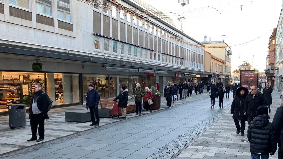 Från Systembolaget i Eskilstuna centrum sträcker sig kön bort till Kyrkogatan. Men bli inte avskräckt, hälsar personalen, som jobbar på effektivt och slussar coronasäkert in ett antal kunder i taget.