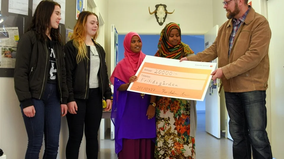 Per-Anders Lindh överlämnar checken till Ella Phil Holgersson, Julia Wass, Nasteha Avill Hossien samt Khadra Abdi Said. Foto: Morgan Karlsson