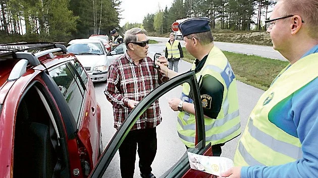 Ingvar Johansson blåser. Håkan Karlsson håller fast blåsapparaten och Jimmy Alexandersson, MHF, står färdigt med papperna.