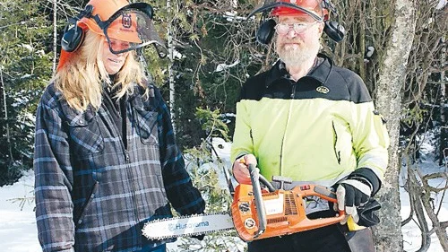 Annika Deltin lär sig att hantera en motorsåg på säkert sätt. Tord Wessman är kursledare.