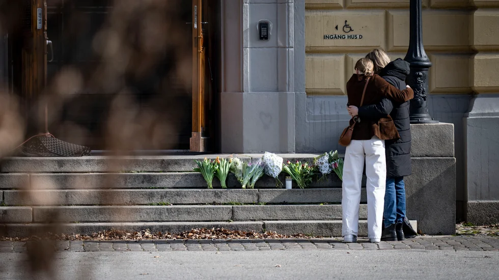 Sörjande lade blommor på trappan vid huvudingången på Malmö Latinskola, där två lärare dödades. 